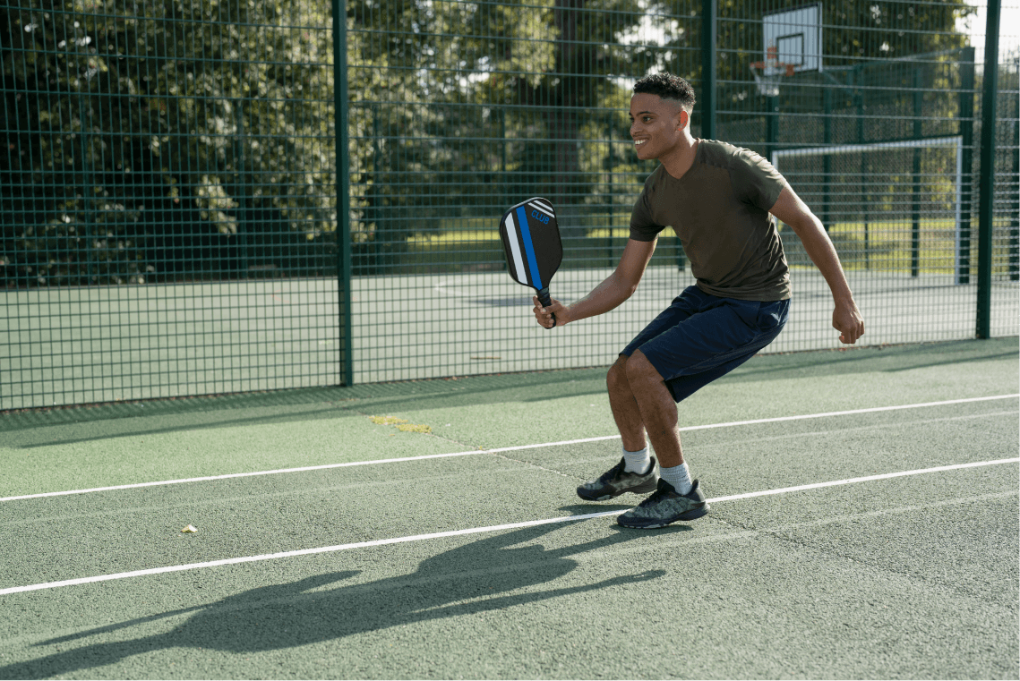 pickleball player in an athletic stance about to volley