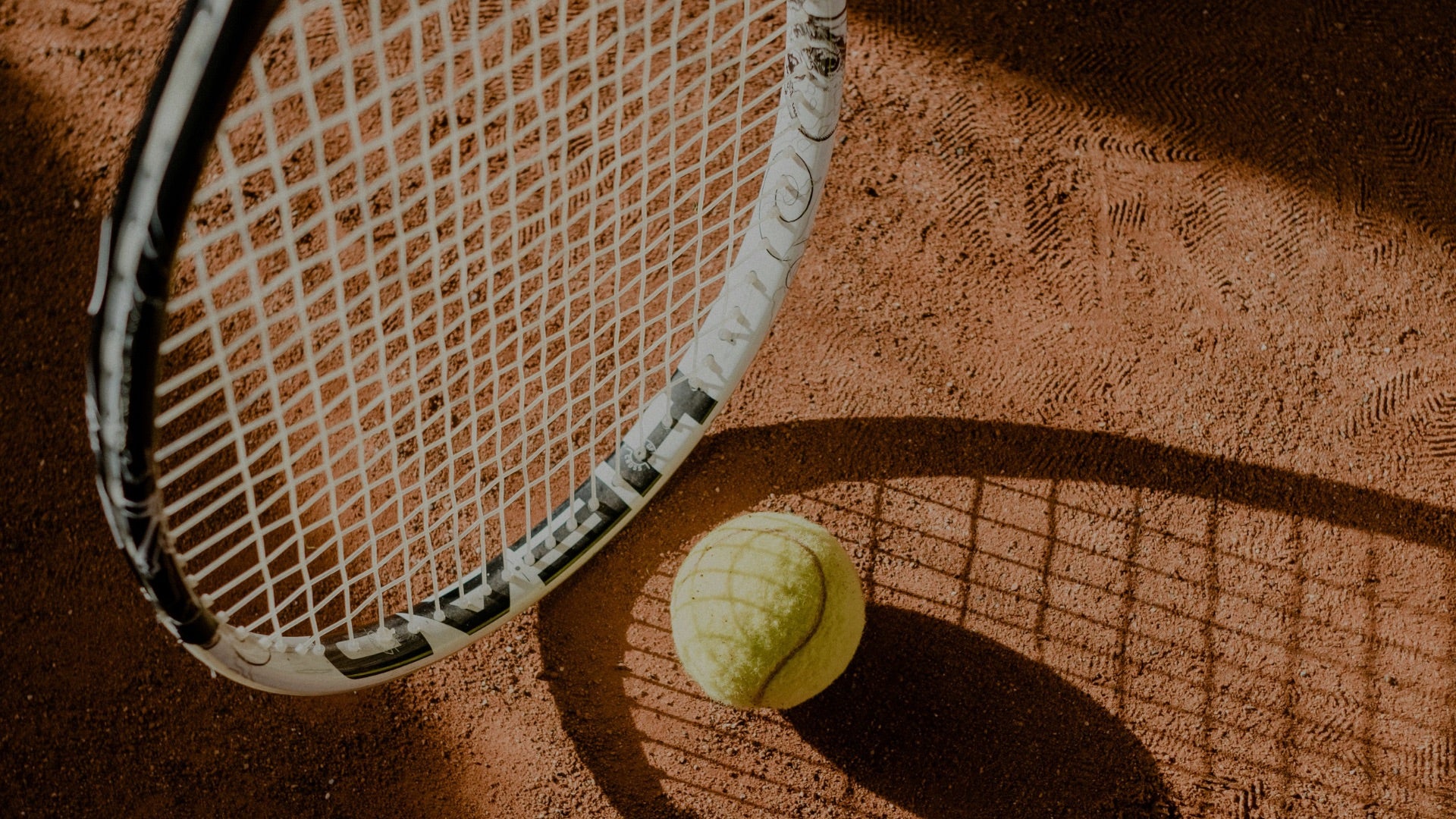 Tennis racket and ball on a clay court